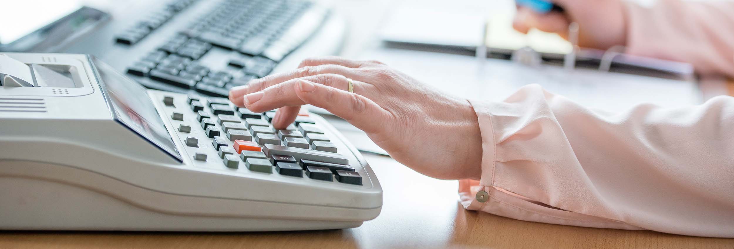 Hand auf Rechenmaschine